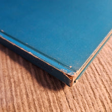 Close-up of a blue book corner on a textured brown surface