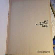 Book titled 'The Beatle's Illustrated Lyrics' on a textured surface, inside front cover
