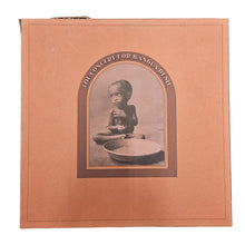 concert for bangladesh box set by george harrison. Album cover with a vintage-style photograph of a child on a textured surface