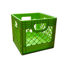 A small bright green plastic crate with integrated handles sits on a wooden tabletop in a store setting.