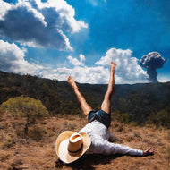 {{product_title}} - Vinyl & CDs at Curious Collections Record Store College Station; person in hat lying on ground with explosion cloud in background, desert landscape, blue sky