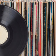 Assorted vinyl records in sleeves and a close-up vinyl disc - Vinyl & CDs at Curious Collections Record Store College Station